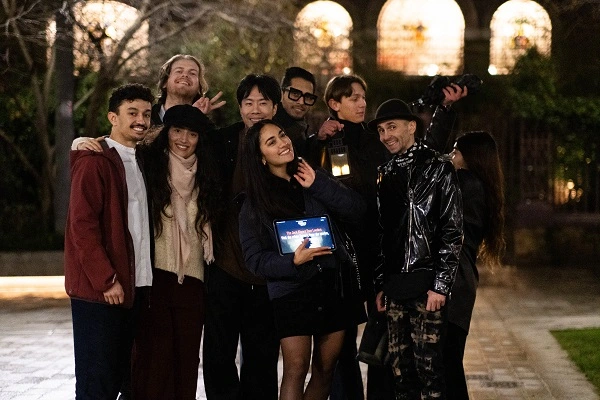 Happy group of visitors posing together after completing the Jack the Ripper walking tour at night
